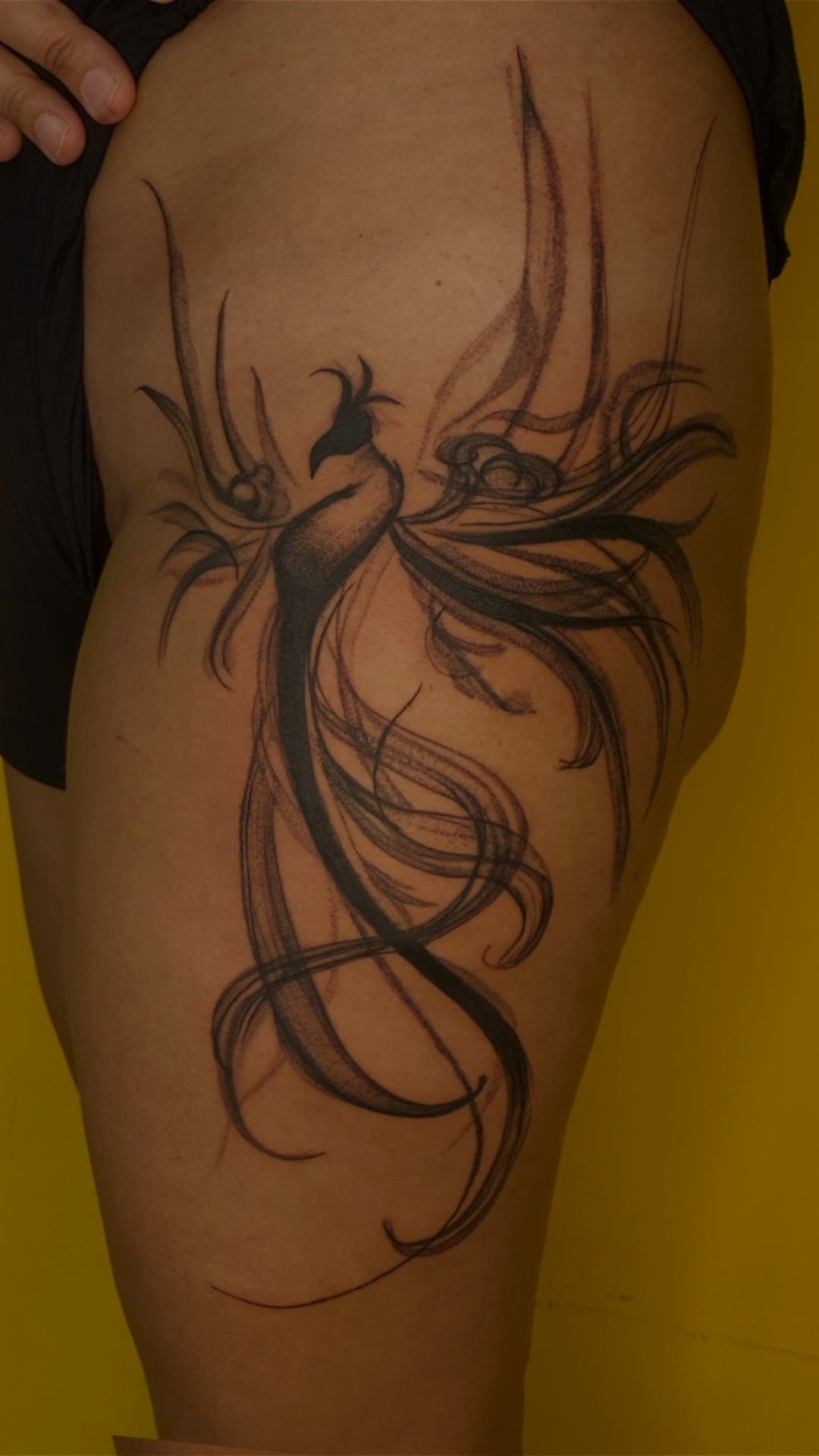 Tatuagem de fênix em estilo abstrato na coxa